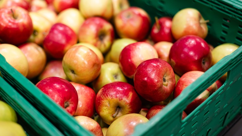 Lots of red and yellow apples on the counter at the food market.