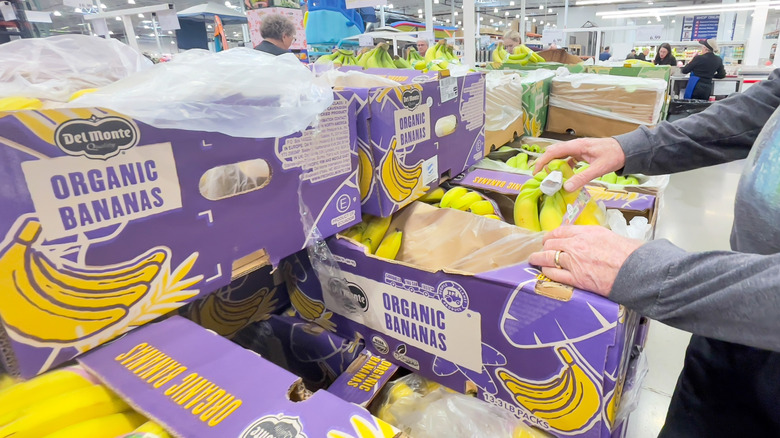 A woman customer looks at produce at Costco.