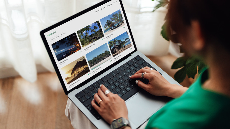 A person using a laptop computer for vacation planning