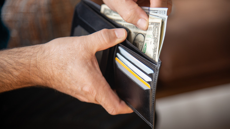 hand taking cash out of a wallet