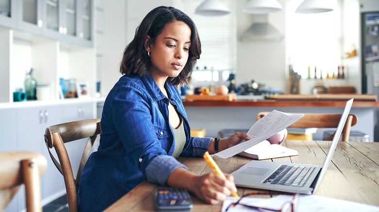 Person working on computer, paperwork