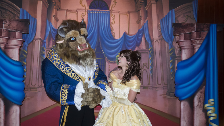 Actors portray Beast and Belle on a stage