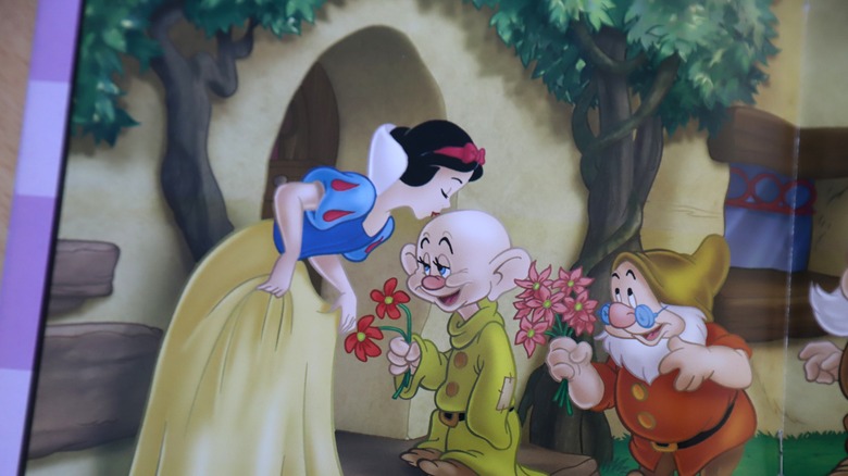 Disney's Snow White accepts flowers from a dwarf
