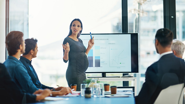Pregnant woman giving work presentation