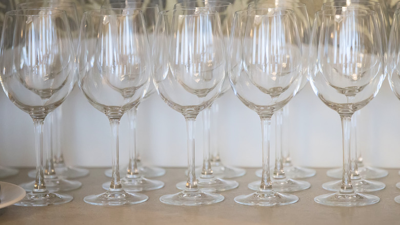 three rows of clear wine glasses on a table
