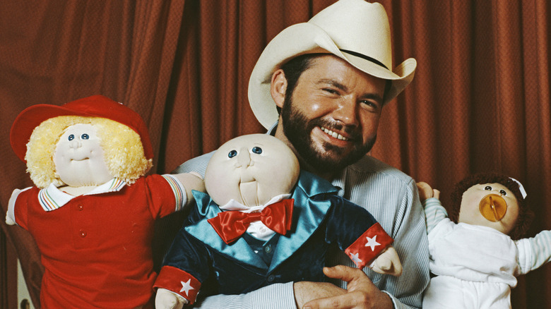 Doll maker Xavier Roberts with three dolls