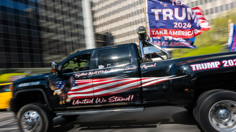 A truck with Trump 2024 designs and flags drives through New York City in 2024.