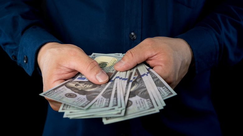 Wad of cash held spread out in a person's hands