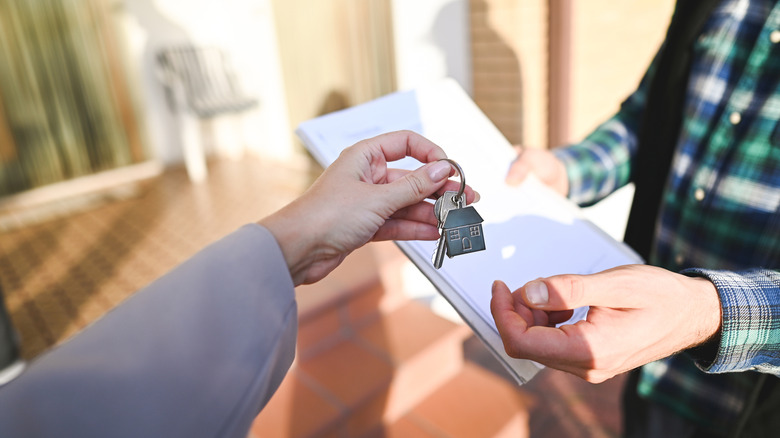 Person giving house keys to another person