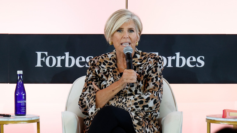 Suze Orman speaking on stage at an event.
