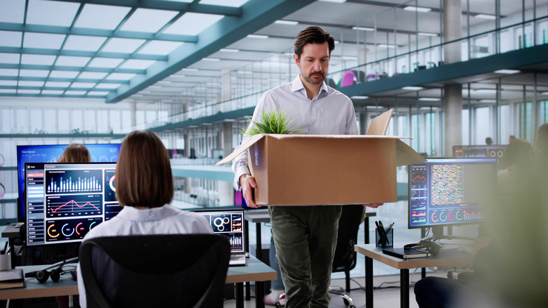 Person leaving office with personal belongings.