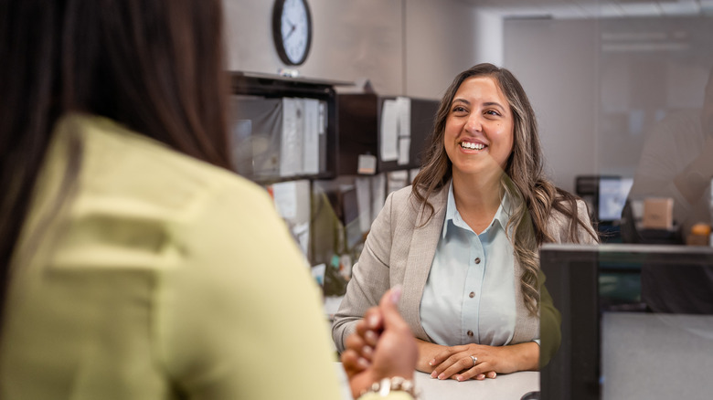 Person speaking with a bank teller at a bank