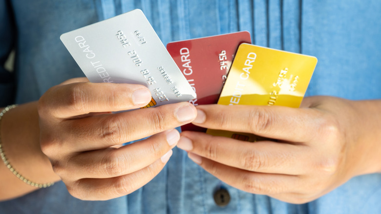 Close up of hands holding three credit cards