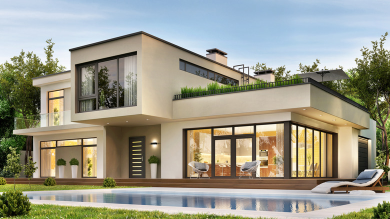 white modernist two-story home with pool and second-story terrace