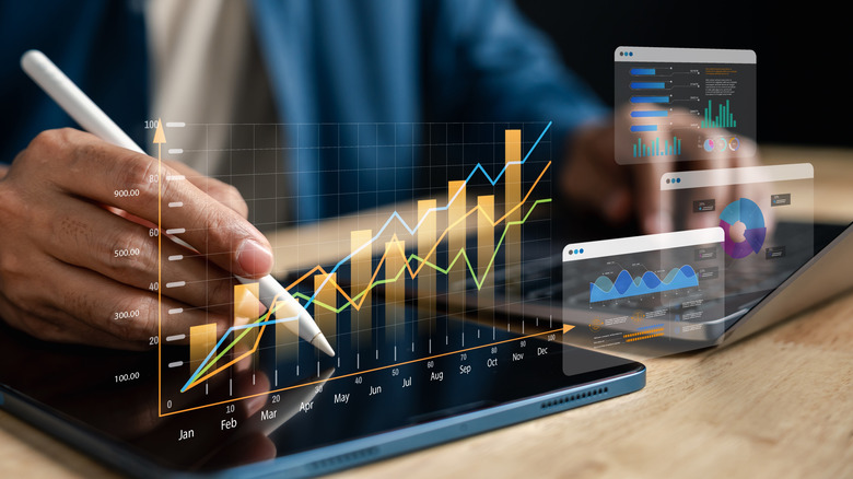 various charts superimposed over a tablet and laptop