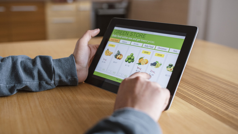 Person ordering groceries online on tablet