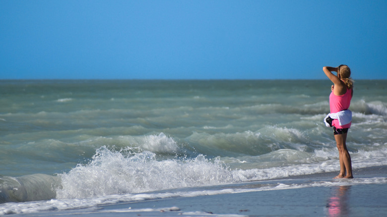 Woman on the beach looking at the ocean