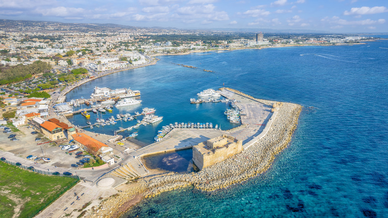 An overhead image of a port an ancient port in Paphos, Cyprus, with modern infrastructure in the background