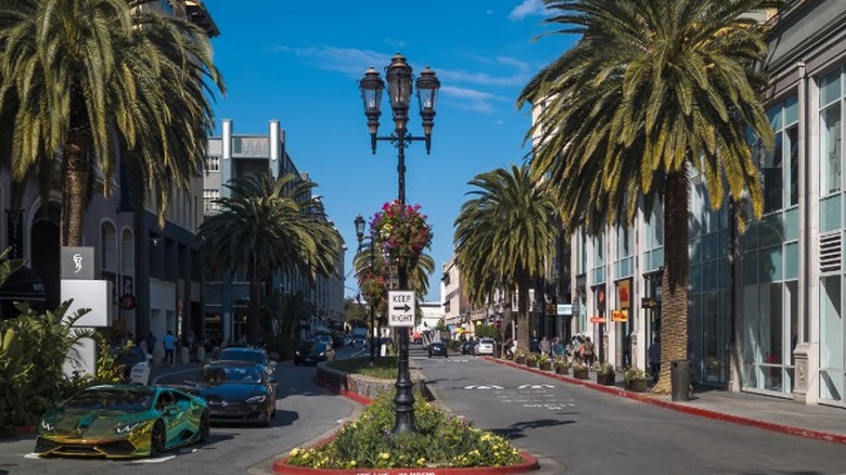 An upscale shopping district with luxury cars driving down the road in downtown San Jose, California.