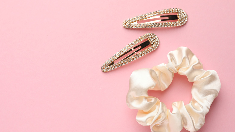 Hair scrunchie and bedazzled hair clips laid on flat surface viewed from above