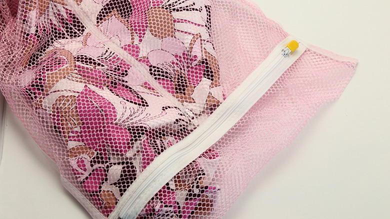 Zippable mesh laundry bag filled with laundry laid on flat surface