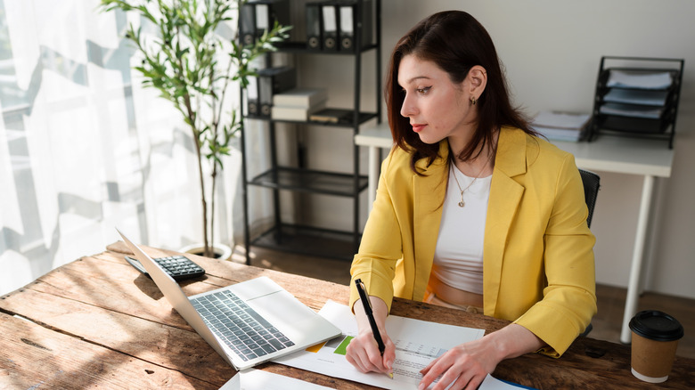 A young woman looking over charts in an office