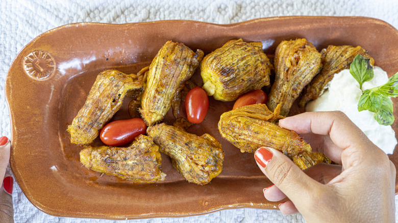 A person taking the traditional stuffed zucchini flowers in a Greek taverna, Crete island, Greece
