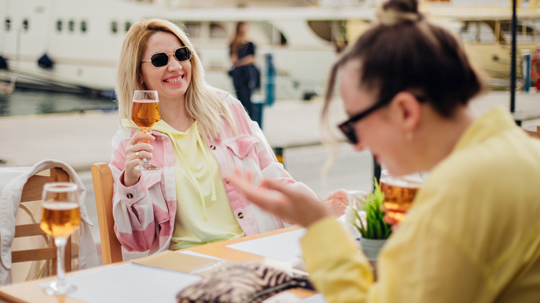 Young happy tourists enjoy drinks at an outdoor restaurant