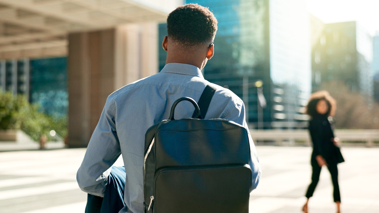 Young man with backpack walking in a city