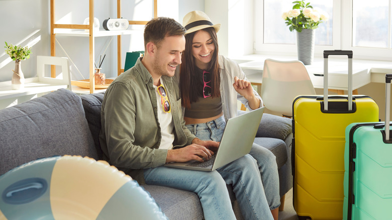 Couple booking travel on laptop.