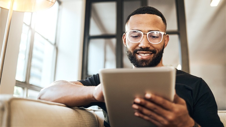 Person smiling while using tablet