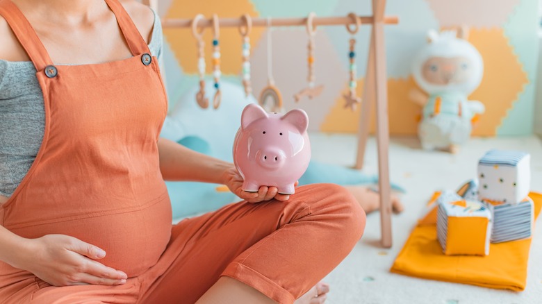 A pregnant women with a piggy bank