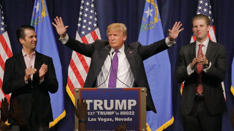 Donald Trump on stage next to his sons Eric Trump and Donald Trump Jr. at a 2016 campaign rally