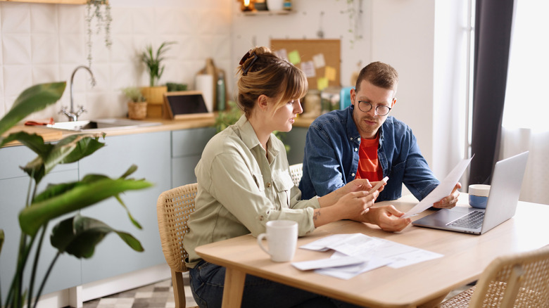 A couple looking at bills at the kitchen table