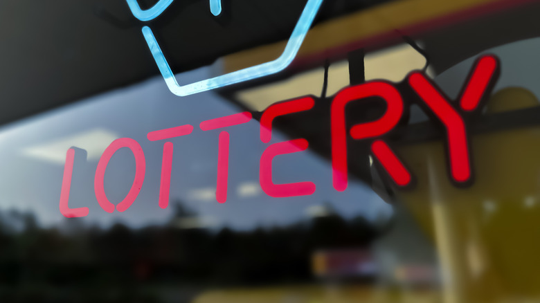 A red neon sign reading 'lottery'