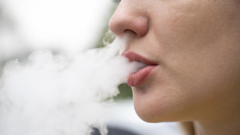 Close up of a mouth blowing out vapor