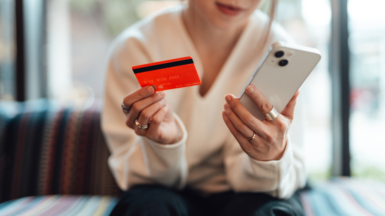 woman holding phone and credit card