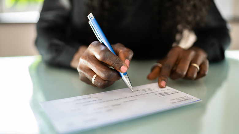 Person writing a check