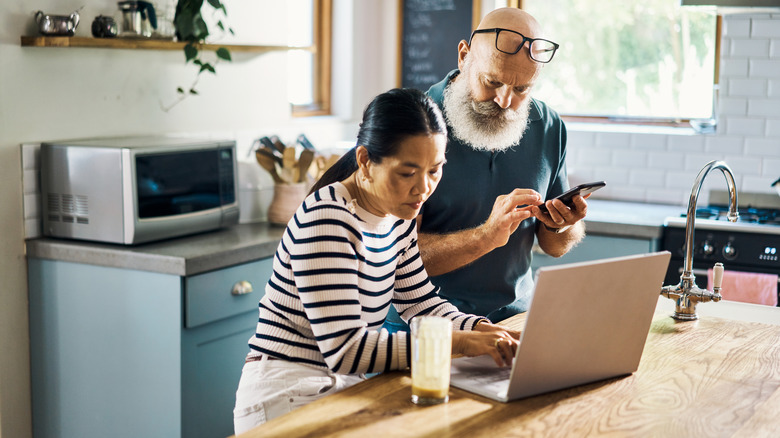 Mature couple looking at laptop in kitchen
