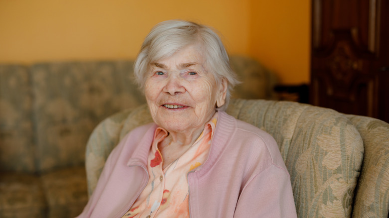 Smiling old woman in a chair.