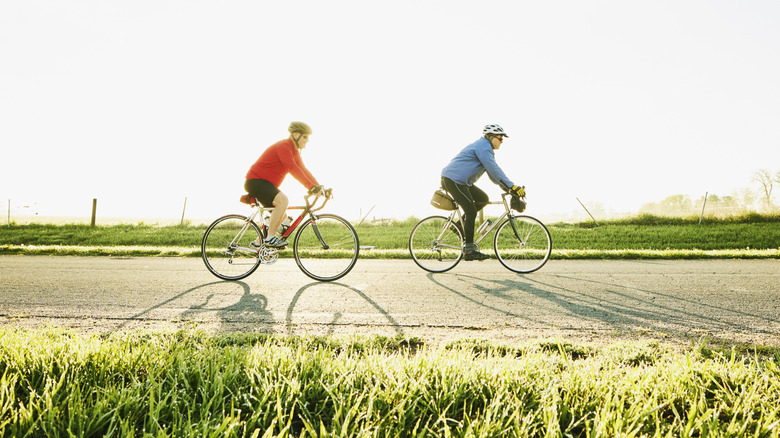 Two people people riding bikes on sunny day