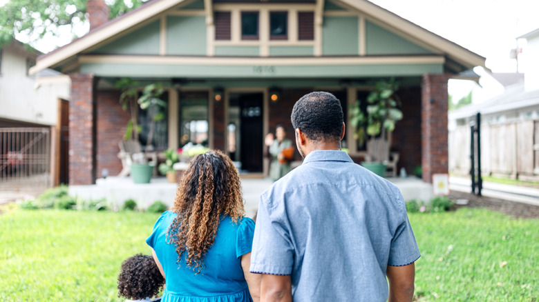 A family looking toward a house.