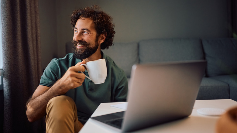 Smiling young man drinking his morning coffee