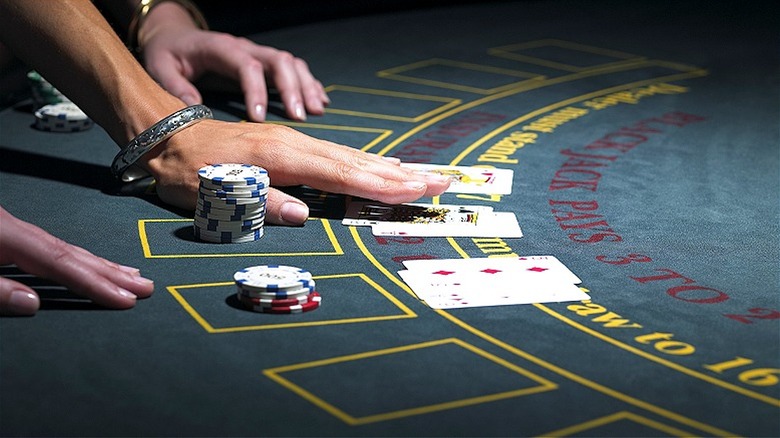 Person reaching for blackjack hand