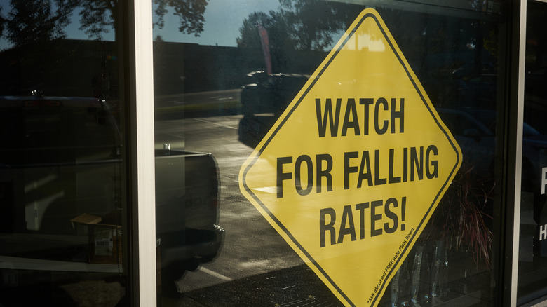 A yellow traffic sign warning of falling interest rates