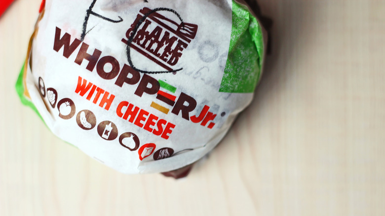 Whopper Jr. with cheese on a wooden surface