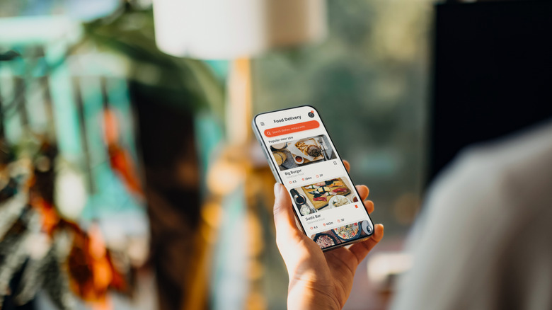 A person using meal delivery service and ordering food online from the menu