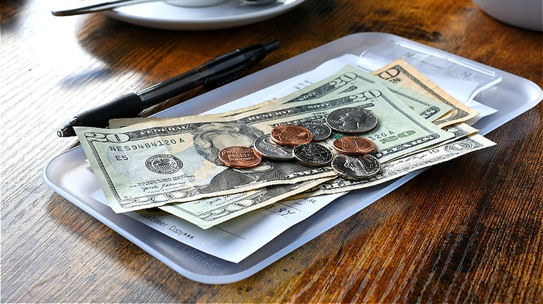 A restaurant check with cash