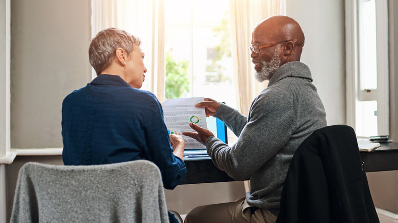 An older couple sitting at a desk reviewing their finances