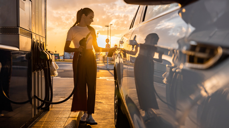 Women fills car with gas.